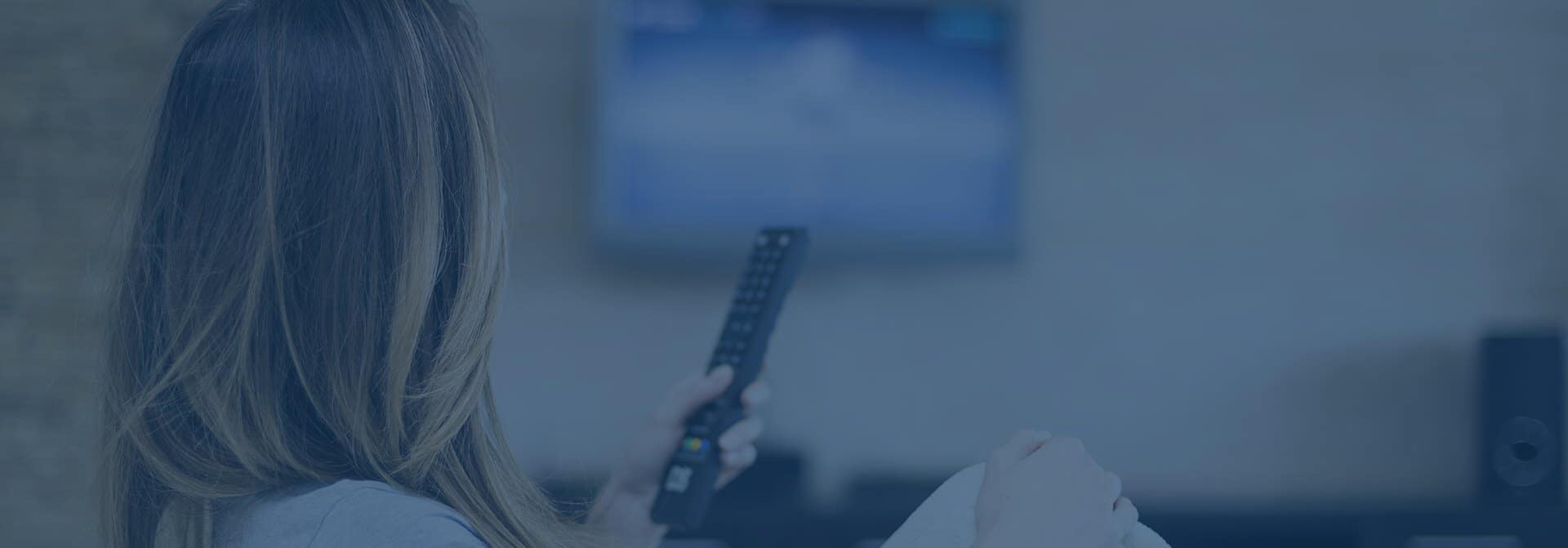 woman holding a tv remote